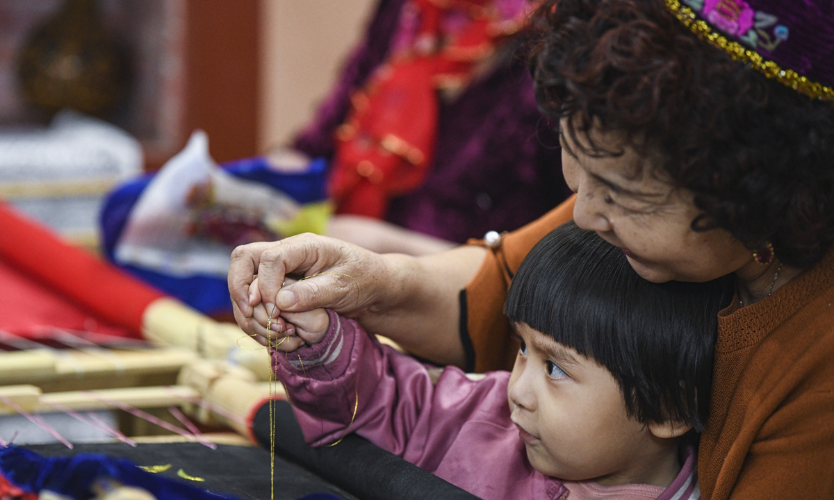 An embroider teaches her granddaughter embroidery skills in Hami, Northwest China's Xinjiang Uygur Autonomous Region on March 19. Photo: Xinhua