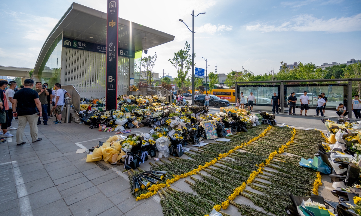 People present flowers at the entrance to Shakoulu subway station on Line 5 in Zhengzhou, Central China's Henan Province on Tuesday to commemorate the victims who died when a subway train was flooded after heavy downpours hit the city on July 20. Photo: VCG
