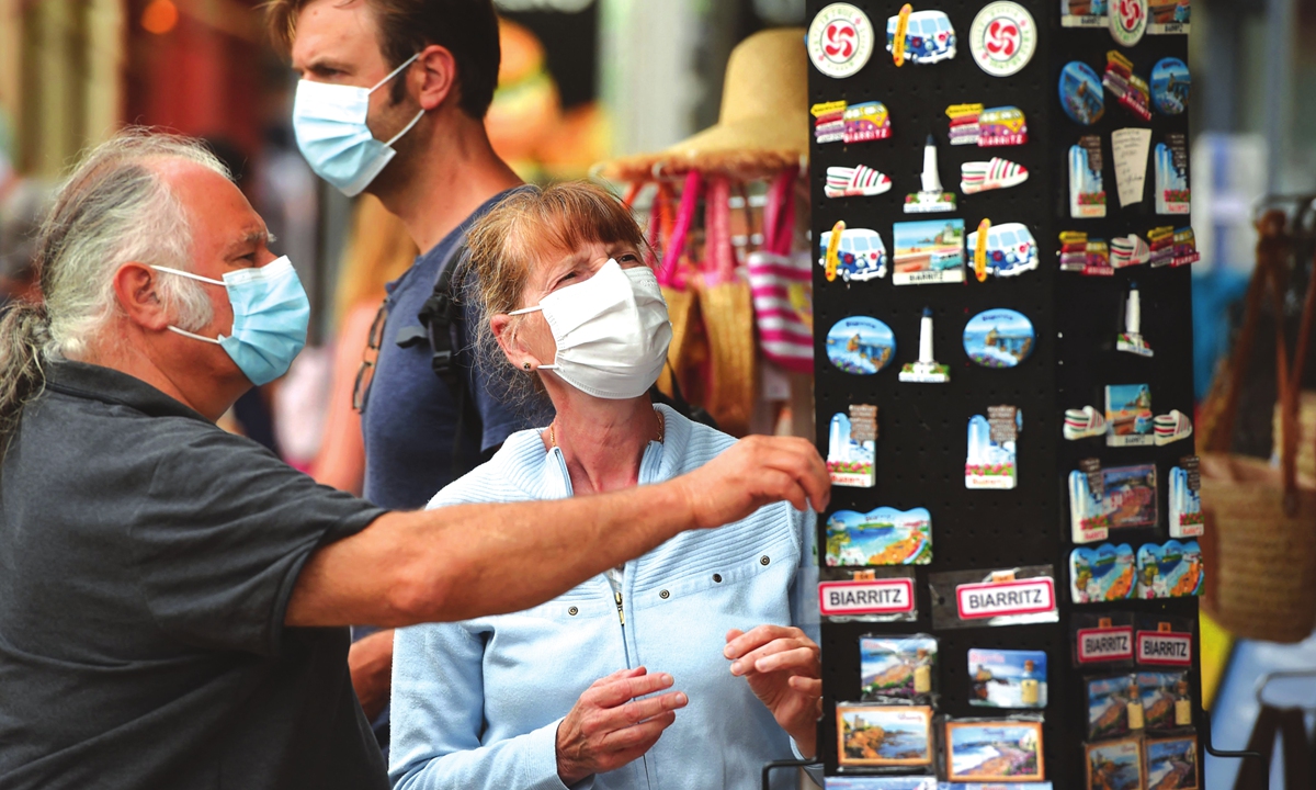 People wearing protective masks look at souvenirs in Biarritz, southwestern France, on Tuesday. France's highest constitutional authority said on Monday it would rule next week on new legislation passed by parliament that would make vaccine passes a key part of daily life for people in the country. Photo: VCG