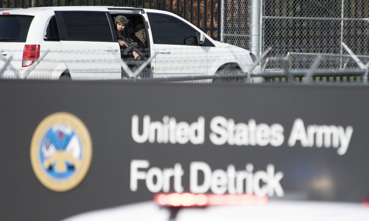 A member of the Frederick Police Department Special Response Team peers out of a minivan before the team entered Fort Detrick on April 6. Photo: VCG