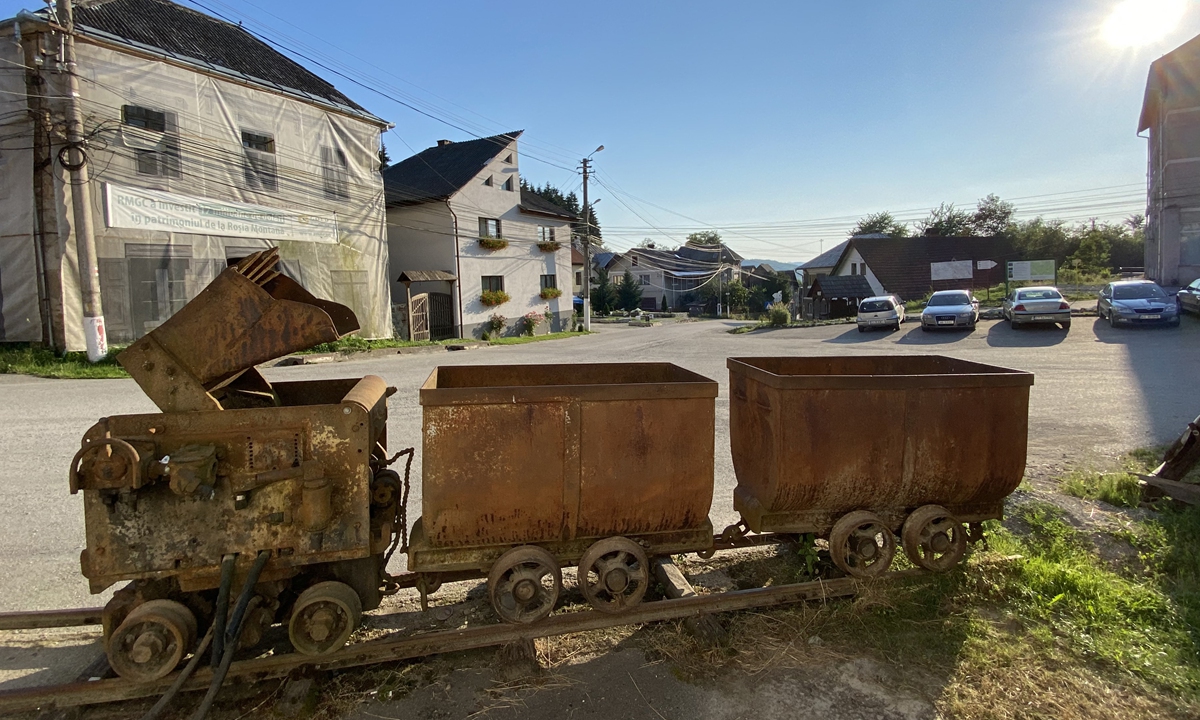 Mine carts once used to transport ore containing gold on show in the village of Rosia Montana, western Romania, on July 12 
Top: Volunteers work on the restoration site of a house in the village of Rosia Montana, western Romania, on July 13. Photos: AFP