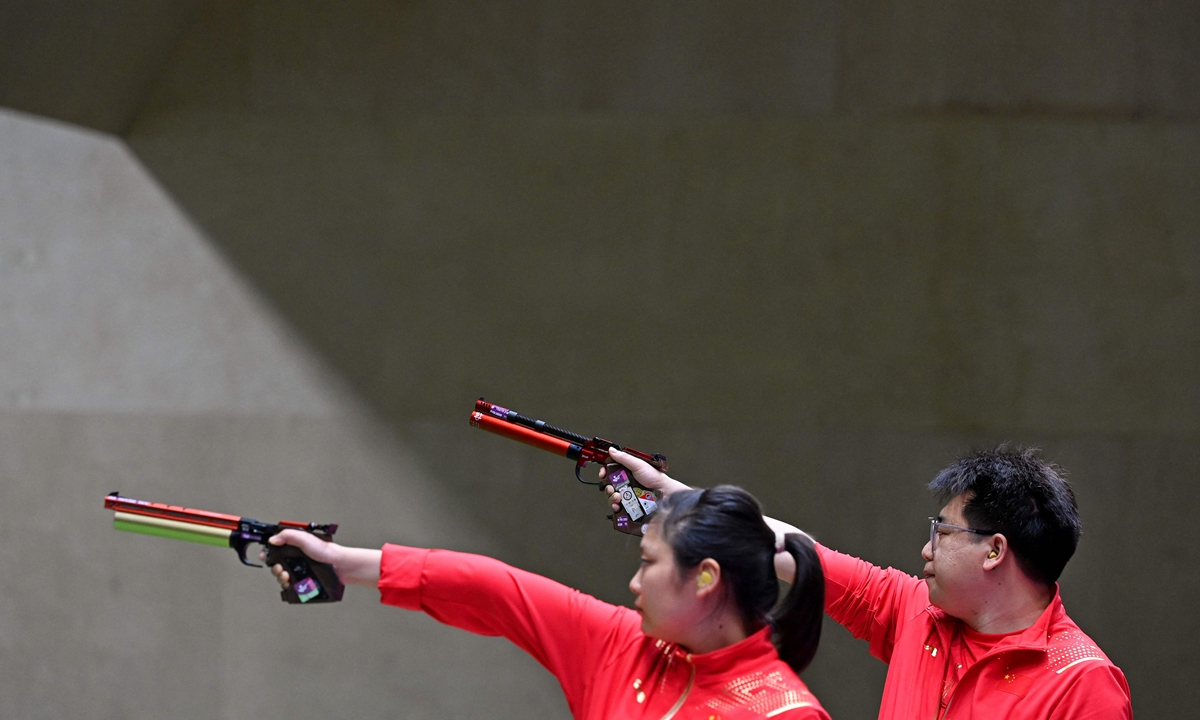 China's Jiang Ranxin (left) and Pang Wei compete in the 10-meter air pistol mixed team final during the Tokyo Olympic Games on Tuesday. Photo: AFP