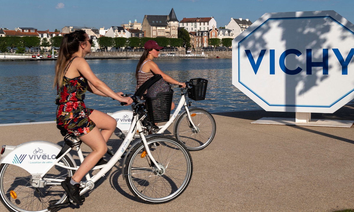 Two women ride their bikes in Vichy, France, on June 24, 2020. Photo: AFP