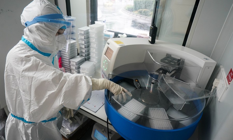 A staff member works in a temporary laboratory for nucleic acid testing at the square of the Nanjing Railway Station in Nanjing, capital of east China's Jiangsu Province, July 27, 2021.(Photo: Xinhua)