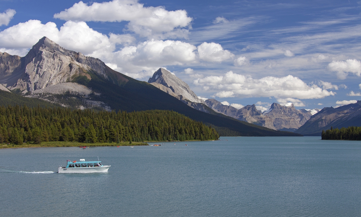 Canoes and tourist boat on Maligne Lake in the Jasper National Park, Alberta, Canadian Rockies, Canada. Photo: VCG