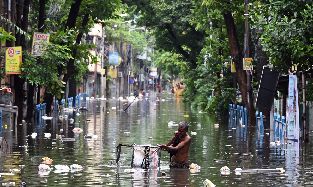 A man pushes his tricycle through floodwaters following rain in Kolkata, India on Friday. Several parts of the city reported waterlog on Friday following a heavy overnight downpour. Photo: AFP