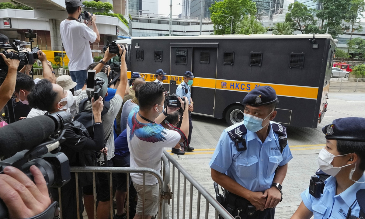 Police officers stand guard as a prison truck carrying Tong Ying-kit leaves a court on Friday. Tong was sentenced to nine years in prison for separatism and terrorist activities. Photo: AP