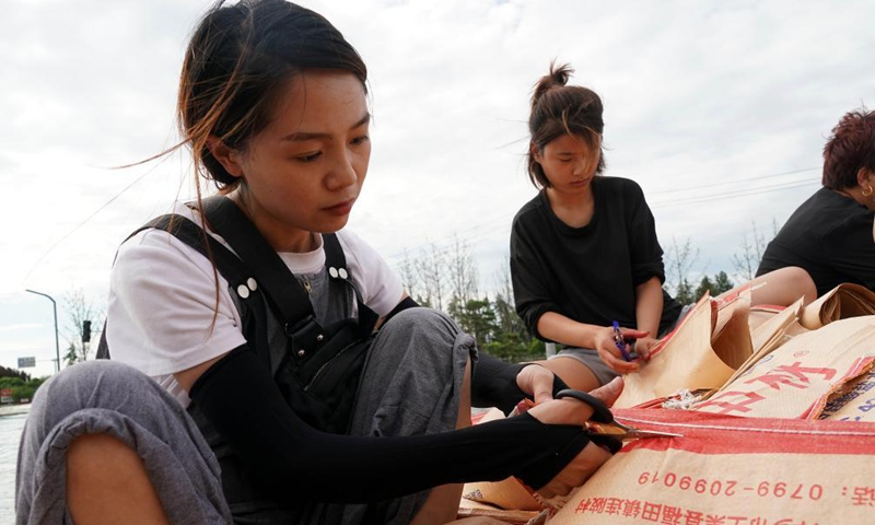 Residents prepare sandbags to reinforce the embankment in Xunxian County, central China's Henan Province, July 29, 2021.Photo:Xinhua