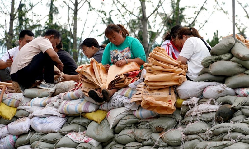 Residents make sandbags to reinforce the embankment in Xunxian County, central China's Henan Province, July 29, 2021.Photo:Xinhua