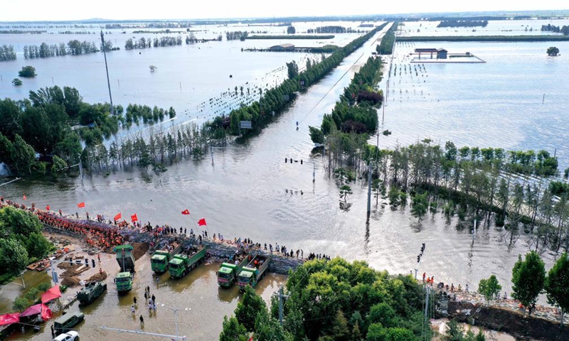 Aerial photo taken on July 29, 2021 shows rescuers and local residents reinforcing the embankment in Xunxian County, central China's Henan Province.Photo:Xinhua