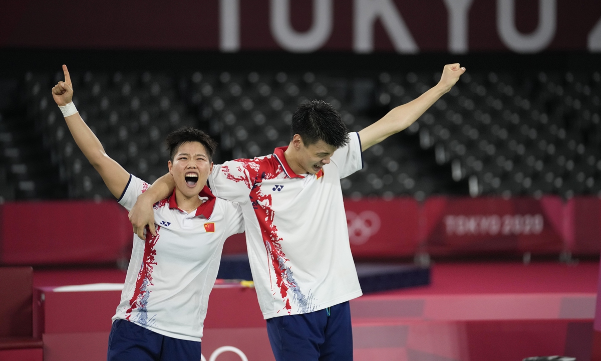 Badminton pair Wang Yilü (right) and Huang Dongping celebrate their Olympic victory after beating teammates Zheng Siwei and Huang Yaqiong to win the badminton mixed doubles gold medal. Photo: VCG