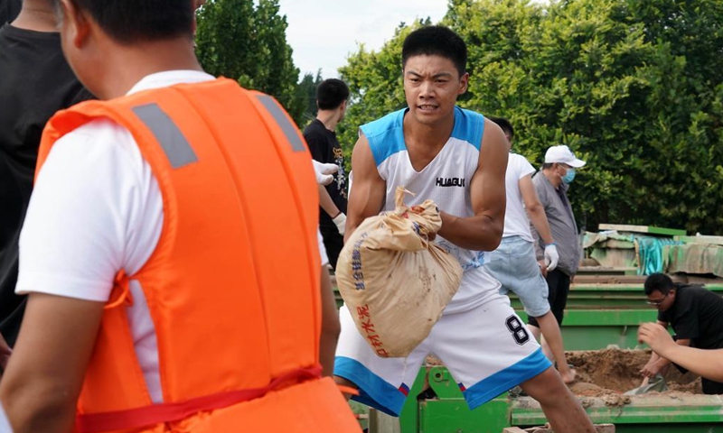 Residents carry sandbags to reinforce the embankment in Xunxian County, central China's Henan Province, July 29, 2021.Photo:Xinhua