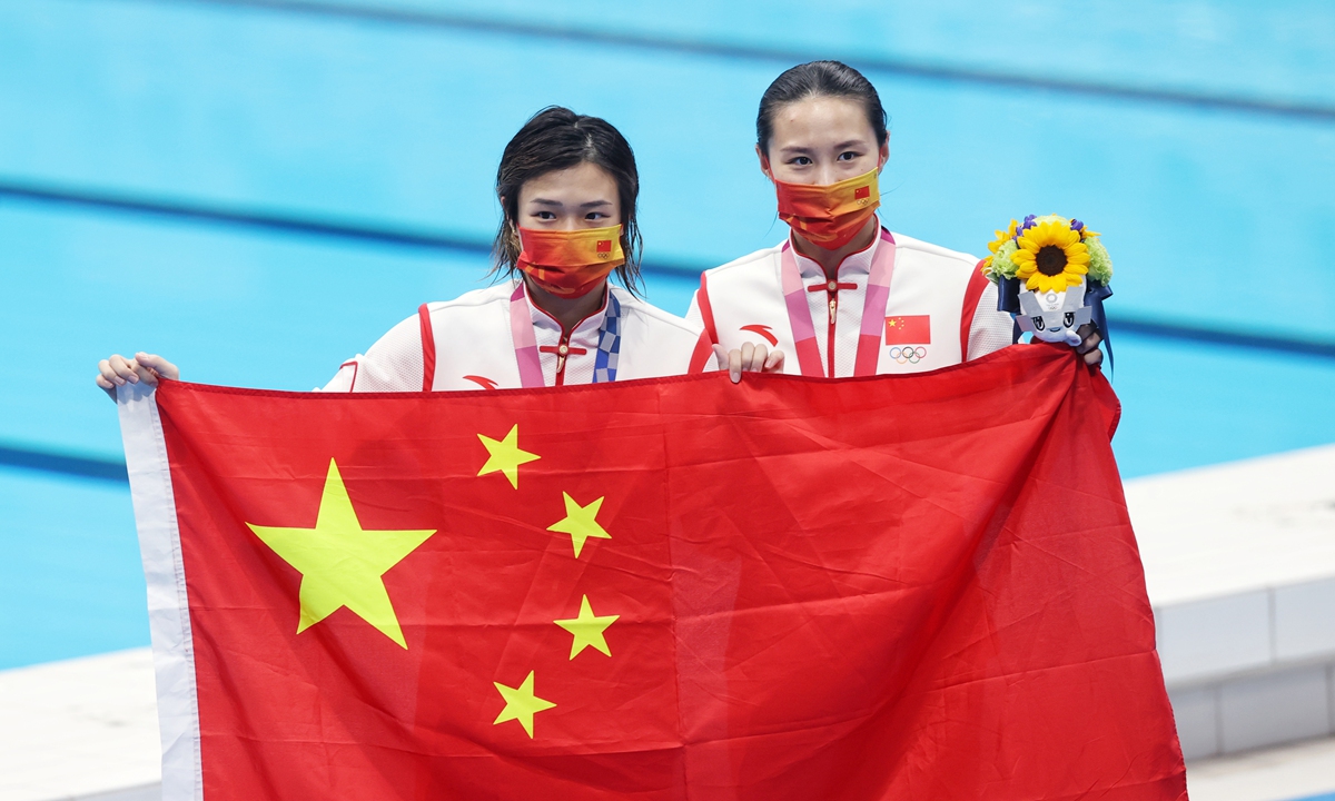 (From left) Gold medalist Shi Tingmao and silver medalist Wang Han pose with a Chinese national flag after the match on Sunday in Tokyo. Photo: Cui Meng/GT
