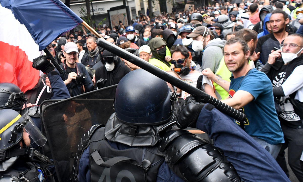 CRS riot police charge demonstrators on the sidelines of a demonstration as part of a national day of protest against French legislation making a Covid-19 health pass compulsory to visit a cafe, board a plane or travel on an inter-city train, in Paris on Saturday. The legislation has sparked mass protests in France but the government is determined to press ahead. Photo: AFP