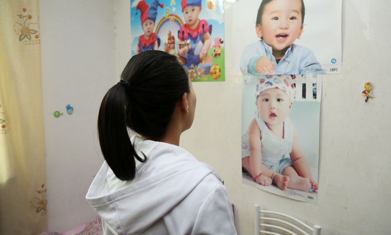 A surrogate mother looks at baby posters in Shanghai. Photo: IC
