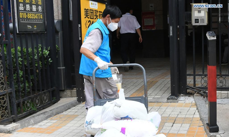A volunteer delivers necessities ordered by residents under home quarantine at a community in Haidian District, Beijing, capital of China, Aug. 3, 2021. One new locally-transmitted confirmed COVID-19 case was reported on Monday in a residential community in Haidian. The community has been put under closed management. (Xinhua/Ren Chao)