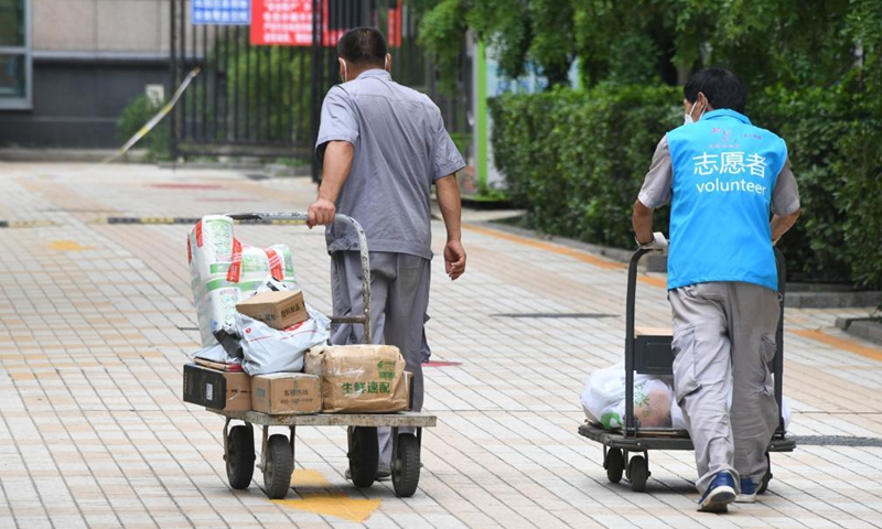 Volunteers deliver necessities ordered by residents under home quarantine at a community in Haidian District, Beijing, capital of China, Aug. 3, 2021. One new locally-transmitted confirmed COVID-19 case was reported on Monday in a residential community in Haidian. The community has been put under closed management. (Xinhua/Ren Chao) 