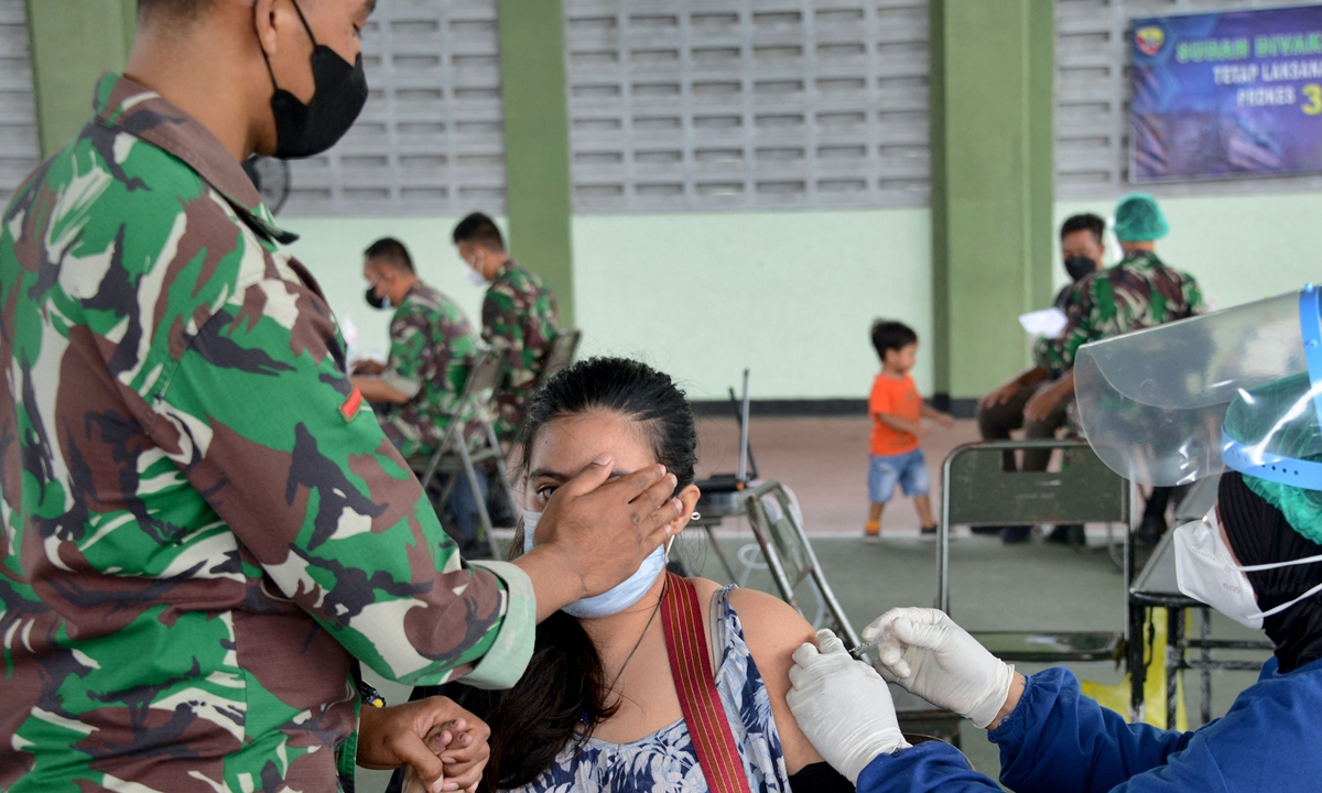 A woman receives the Sinovac COVID-19 coronavirus vaccine at a makeshift mass vaccination clinic in Denpasar, on Indonesia's resort island of Bali on Tuesday. The Southeast Asian country is currently working to inoculate the targeted 181.5 million people, about 70 percent of its total population, by March 2022. Photo: VCG