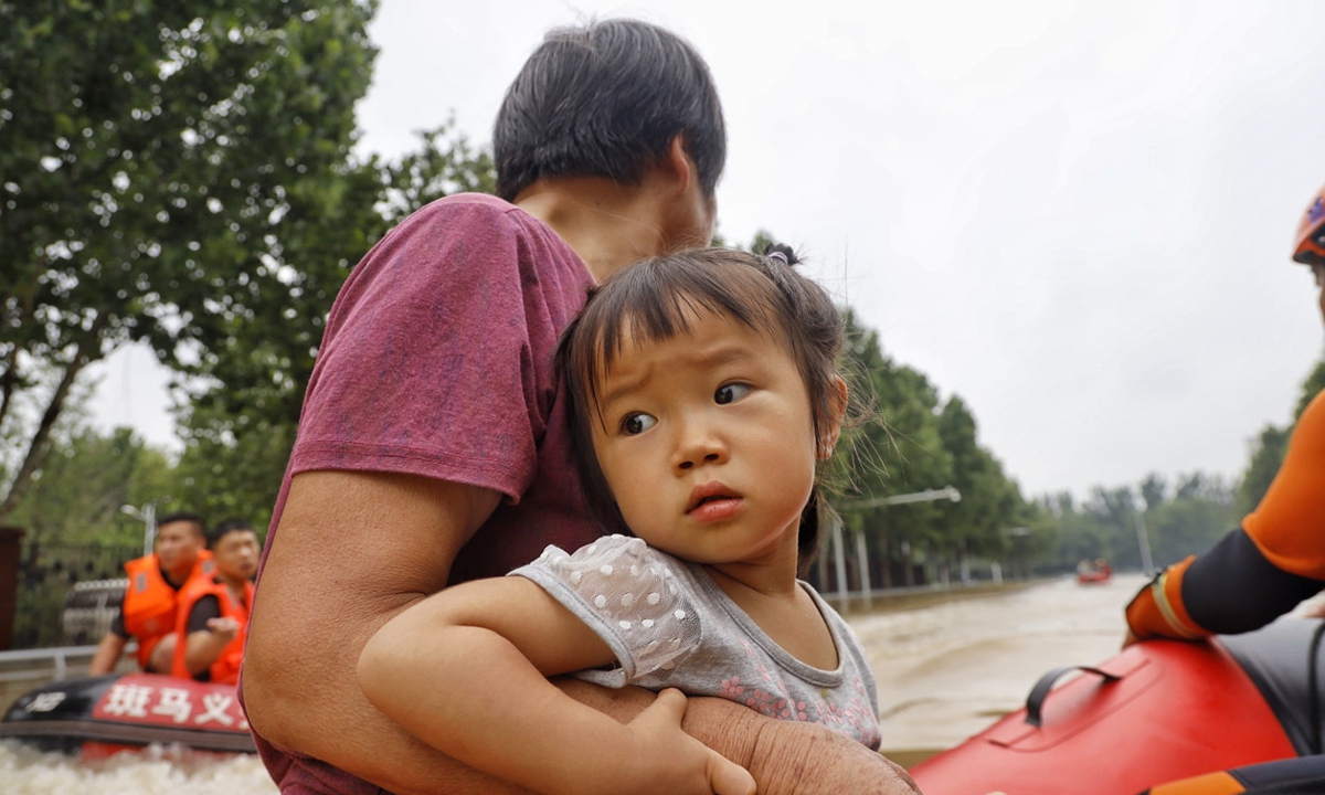 An elderly holds her grandchild who was rescued after being stuck in the floods for over 48 hours in Zhengzhou. Photo: Li Hao/GT