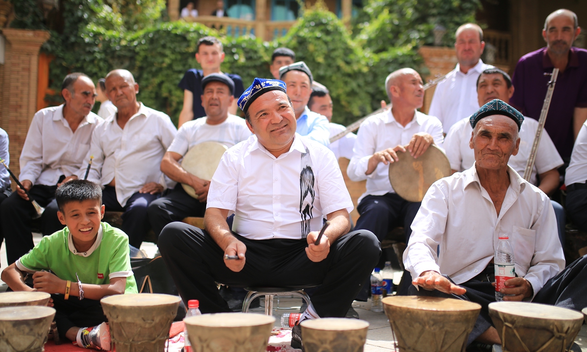 Folk artisans play drums as people dance at the Corban Festival. Photo: Fan Lingzhi/GT