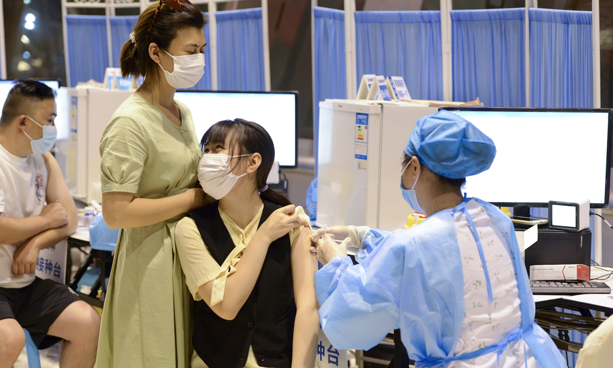 A high school student accompanied by her parents is vaccinated at the COVID-19 vaccination site at Jiangnan Gymnasium in Nan 'an District, Southwest China's Chongqing Municipality, on Sunday Photo: IC