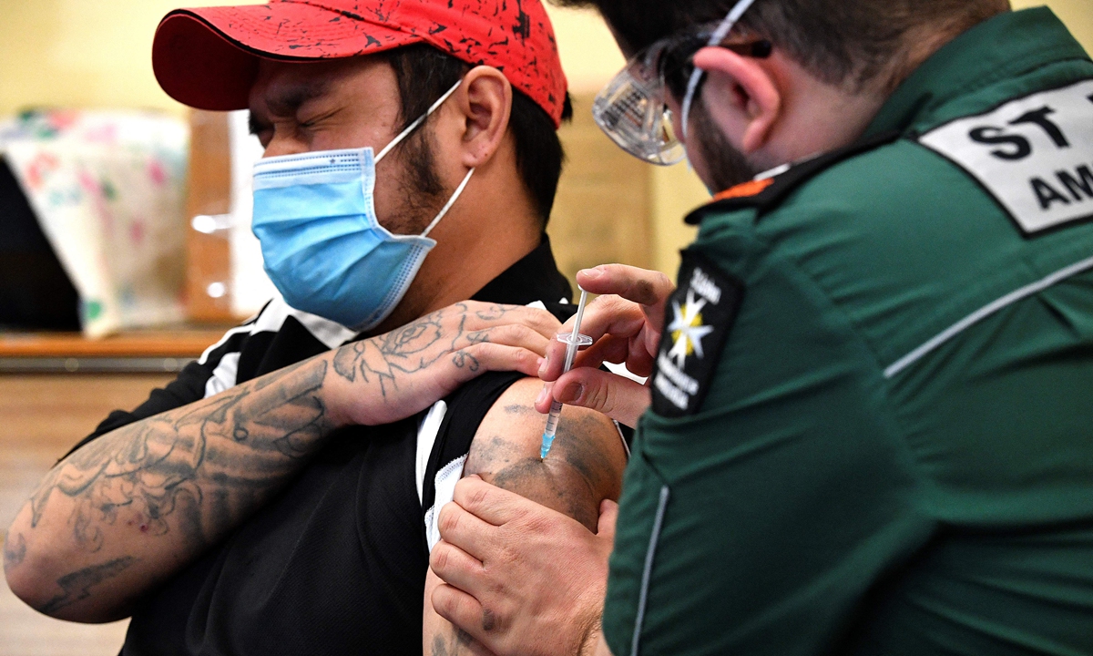 A man gets his first dose of AstraZeneca vaccine at a walk-in COVID-19 clinic inside a Buddhist temple in the Smithfield suburb of Sydney, Australia on Wednesday. The country has reported 34,833 infections as of Wednesday with over 900 deaths. Photo: AFP