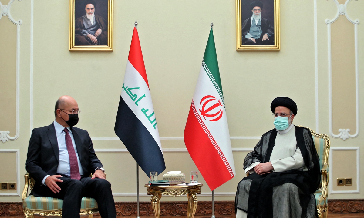 A handout picture provided by the Iranian authority on Thursday shows President Ebrahim Raisi (right) meeting with Iraq's President Barham Saleh in the capital Tehran. Raisi took office on Thursday. Photo: AFP