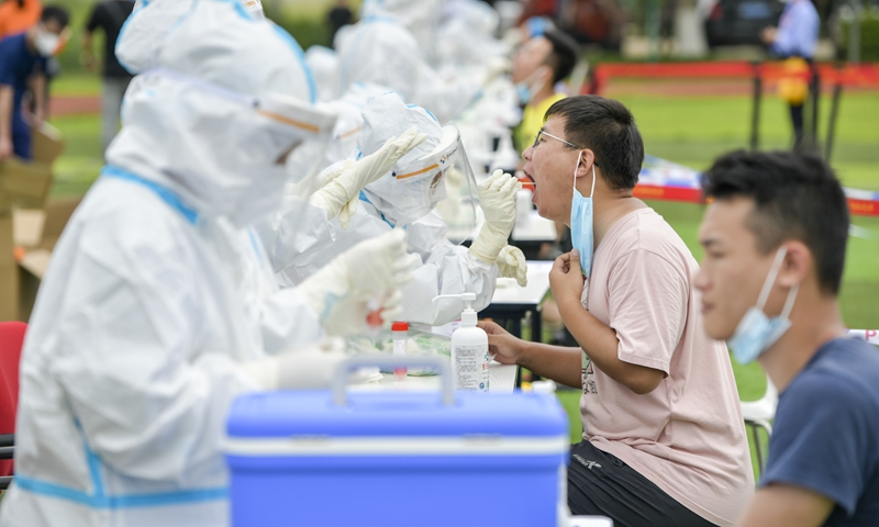 Staffers at Haikou Meilan International Airport take nucleic acid tests on Thursday after a freight company cargo porter tested positive for COVID-19. Photo: VCG