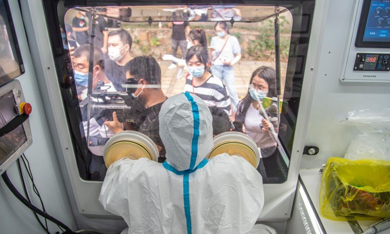 A medical worker works in a mobile lab for COVID-19 nucleic acid testing in Wuchang District of Wuhan, central China's Hubei Province, Aug. 5, 2021.Photo:Xinhua