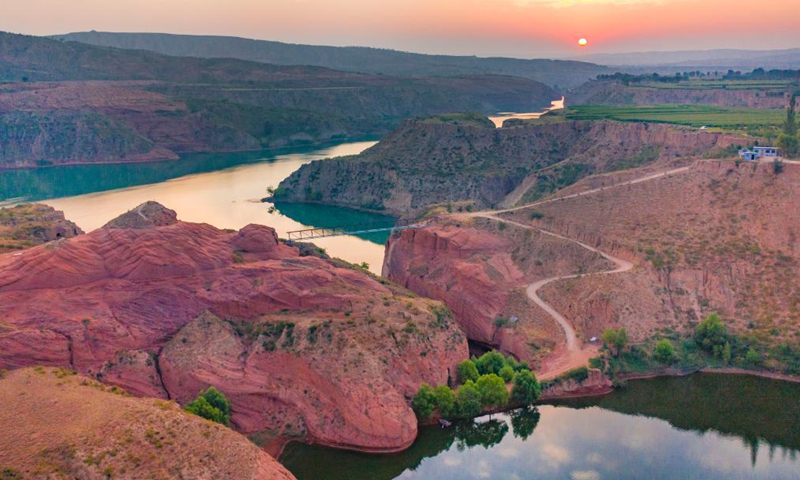 Aerial photo taken on Aug. 6, 2021 shows the Danxia landform, a landscape characterized by reddish sandstone features, in sunrise in Longzhou Town of Jingbian County, northwest China's Shaanxi Province.Photo:Xinhua