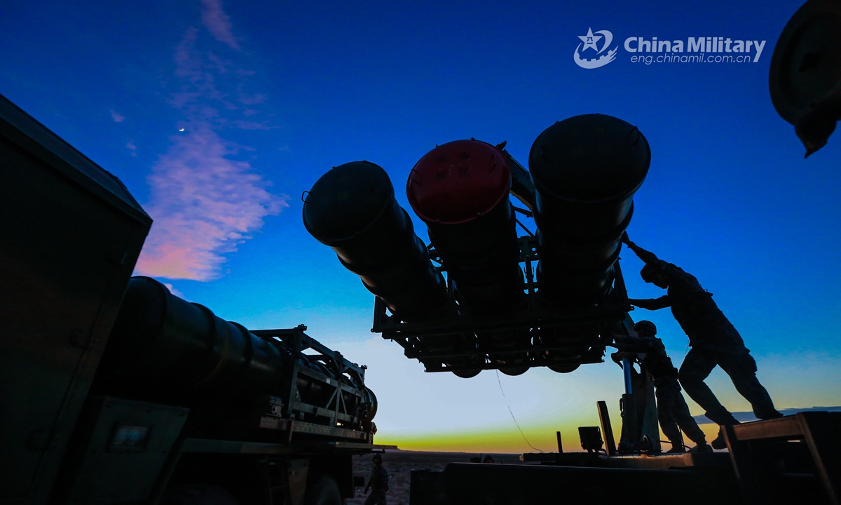 Artillerymen assigned to a missile battalion of an air-defense brigade under the PLA 72nd Group Army operate a crane to hoist and load HQ-16 medium-range air defense missiles onto a missile launching truck during a recent round-the-clock air-defense training exercise in northwest China’s Gobi desert.Photo:China Military
