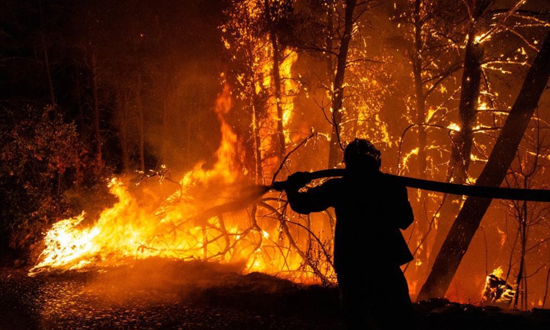 A firefighter tries to put out a wildfire in the north of Athens, Greece, on Aug. 5, 2021.Photo:Xinhua