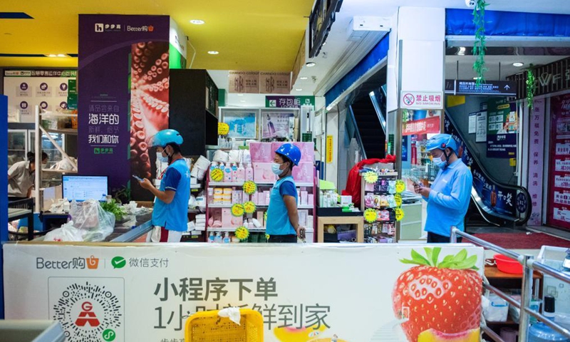 Deliverymen wait to collect customer orders at a supermarket in Yongding District in Zhangjiajie, central China's Hunan Province, Aug. 5, 2021.Photo:Xinhua