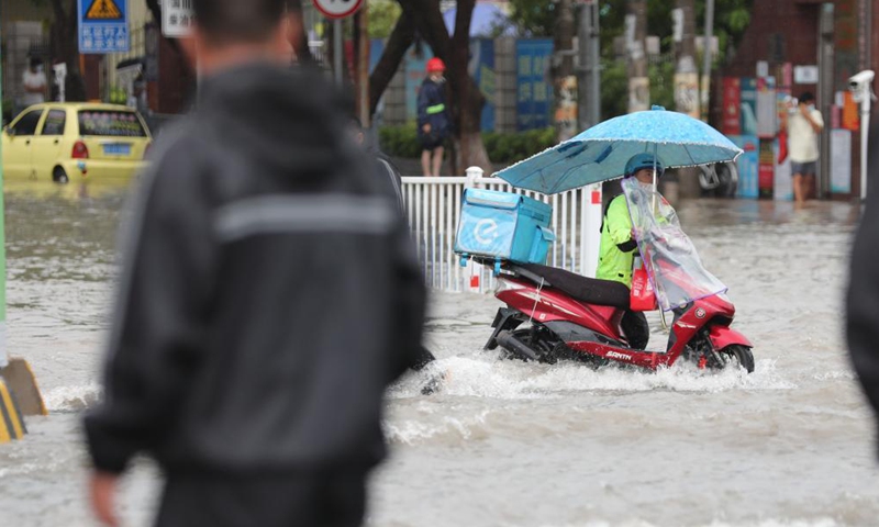 A delivery man wades through a waterlogged road on a motorcycle in Jimei District of Xiamen, southeast China's Fujian Province, Aug. 5, 2021. Typhoon Lupit made its second landfall on Thursday in Fujian Province, bringing heavy downpours and forcing the evacuation of thousands. The local government has initiated an emergency response to flood and waterlogging amid torrential rains brought by Lupit.Photo:Xinhua