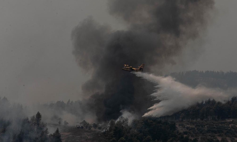 An aircraft tries to extinguish a wildfire in the north of Evia island, Greece, on Aug. 5, 2021. Greek Prime Minister Kyriakos Mitsotakis said on Thursday evening that Greece is facing an extremely critical situation with multiple forest fires at the same time, while saving human lives is the government's top priority. Photo:Xinhua