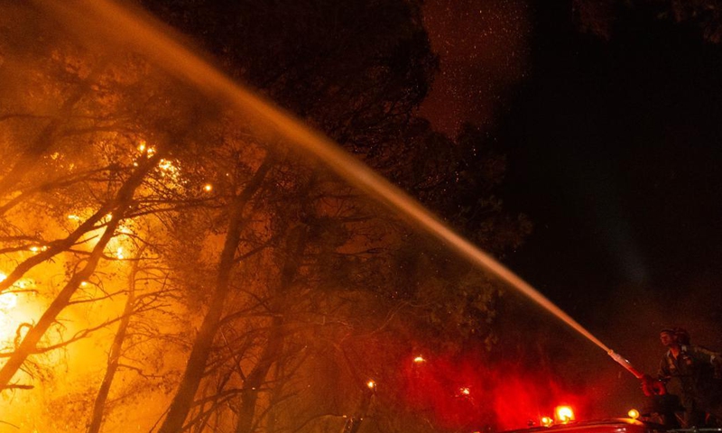 A firefighter tries to put out a wildfire in the north of Athens, Greece, on Aug. 5, 2021.Photo:Xinhua