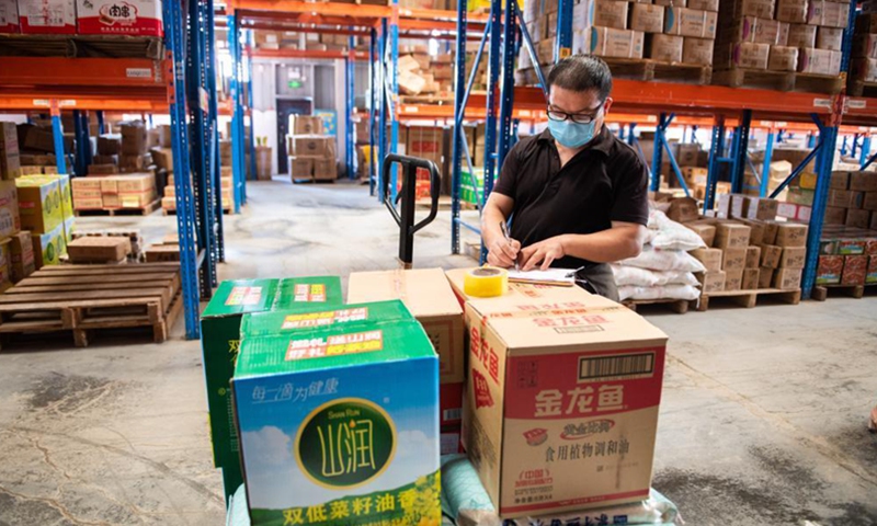 A staff member checks edible oil stock at the distribution center of a supermarket in Zhangjiajie, central China's Hunan Province, Aug. 5, 2021.Photo:Xinhua