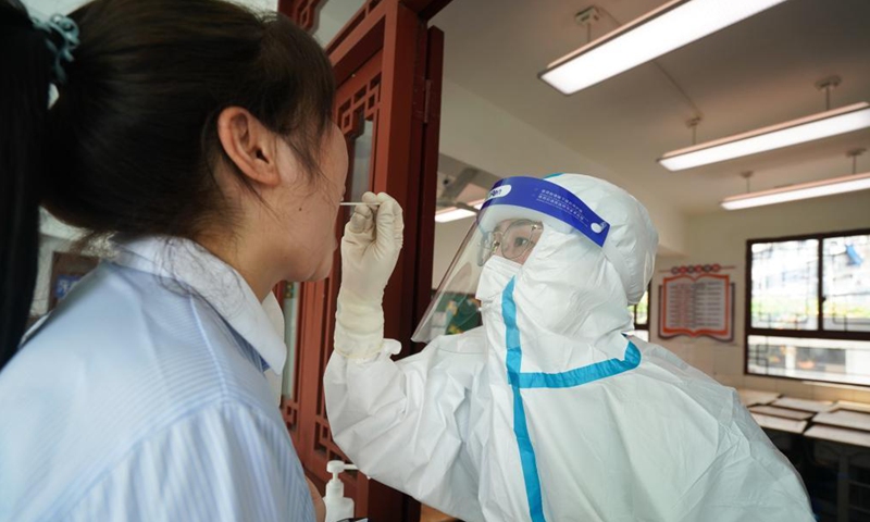 A medical worker takes a swab sample from a woman for COVID-19 nucleic acid test in Nanjing, east China's Jiangsu Province, Aug. 5, 2021. Nanjing launched a fifth round of nucleic acid testing in some areas of the city on Thursday.Photo:Xinhua