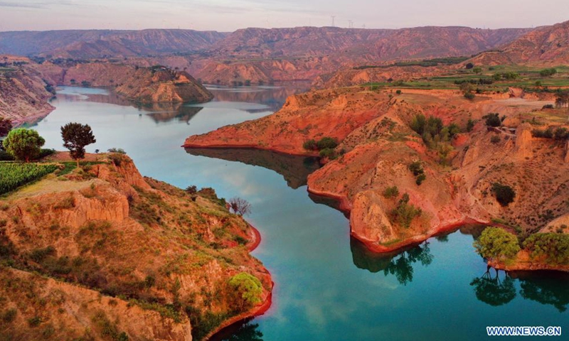 Aerial photo taken on Aug. 6, 2021 shows the Danxia landform, a landscape characterized by reddish sandstone features, in sunrise in Longzhou Town of Jingbian County, northwest China's Shaanxi Province.Photo:Xinhua