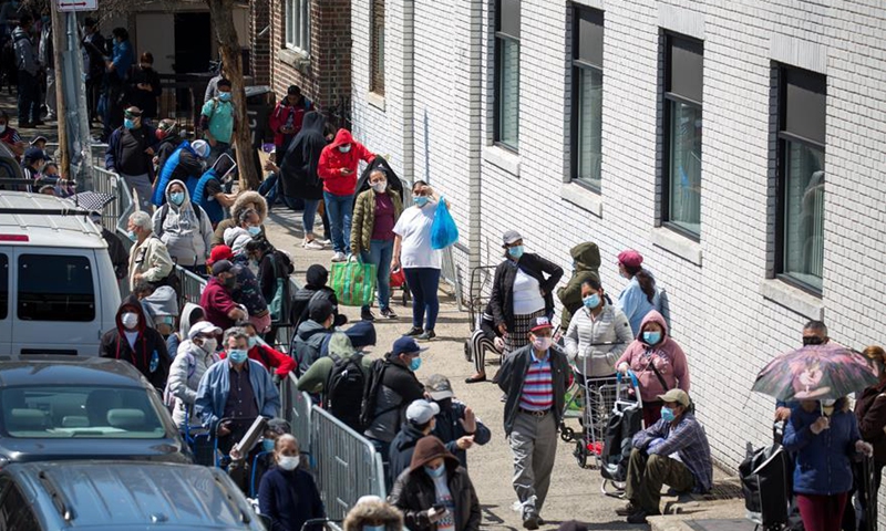 People wait to receive food at a food distribution site in the Brooklyn borough of New York, the United States.File photo:Xinhua