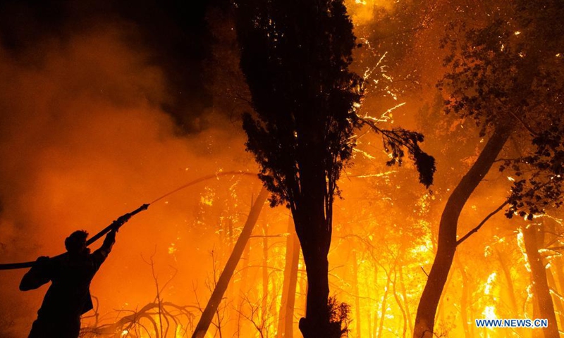 A firefighter tries to put out a wildfire in the north of Athens, Greece, on Aug. 5, 2021.Photo:Xinhua