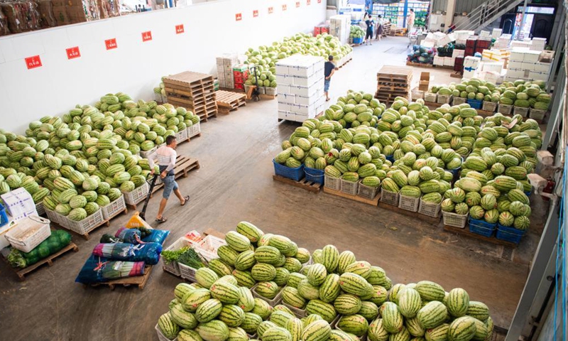 Staff members transfer fruits and vegetables at the distribution center of a supermarket in Zhangjiajie, central China's Hunan Province, Aug. 5, 2021.Photo:Xinhua