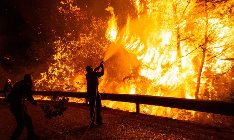 Firefighters try to put out a wildfire in the north of Athens, Greece, on Aug. 5, 2021. Firefighting forces are battling relentlessly to contain the fires that sprung up across Greece.Photo:Xinhua