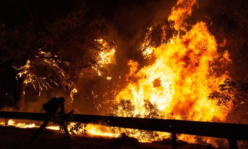 A volunteer tries to put out a wildfire in the north of Athens, Greece, on Aug. 5, 2021.Photo:Xinhua