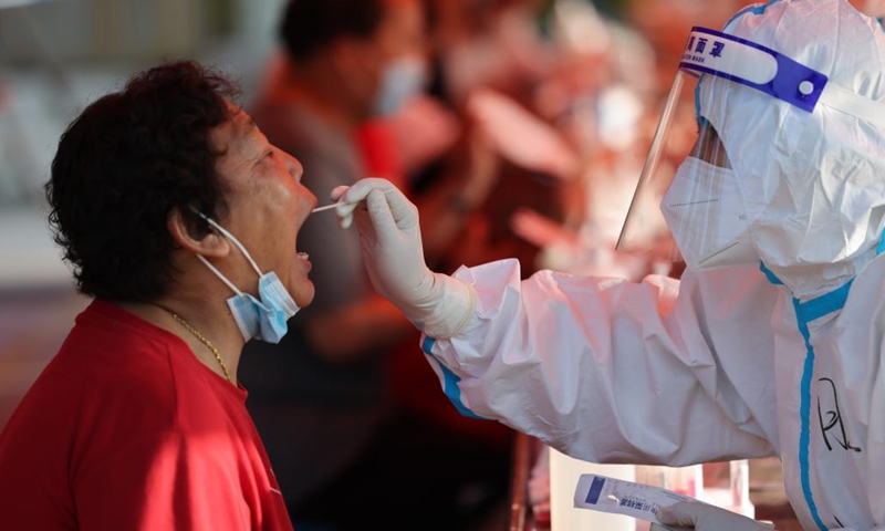 A medical worker takes a swab sample from a citizen for COVID-19 nucleic acid testing in Jiangdu District of Yangzhou, east China's Jiangsu Province, Aug. 6, 2021. Jiangdu District of Yangzhou launched a second round of nucleic acid testing on Friday.Photo:Xinhua