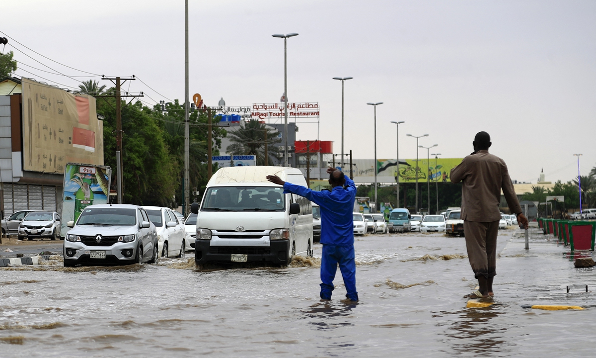 Cars drive along a flooded street in Khartoum after torrential rain fell on the Sudanese capital, almost paralyzing traffic, on Sunday. Photo: AFP