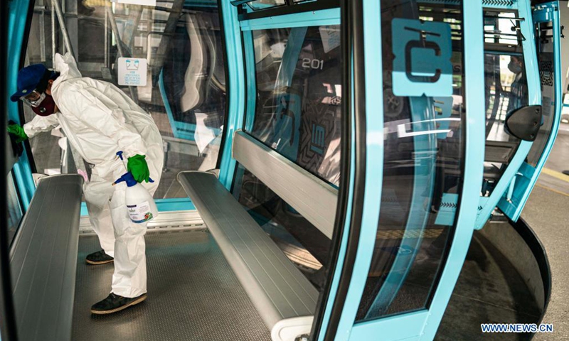 A worker disinfects a cabin during the inauguration of a cable car line for mass transit in Mexico City, capital of Mexico, Aug. 8, 2021. (Xinhua/David de la Paz)