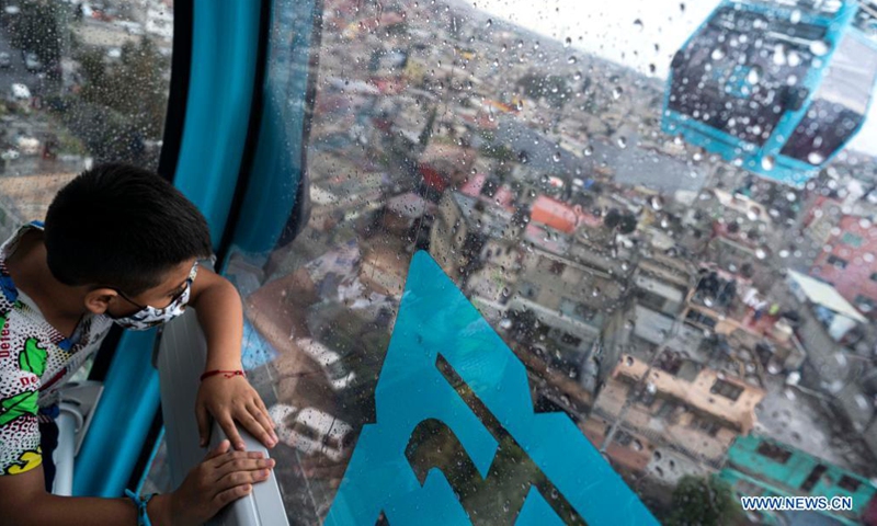 A boy travels in a cabin during the inauguration of a cable car line for mass transit in Mexico City, capital of Mexico, Aug. 8, 2021. (Xinhua/David de la Paz)