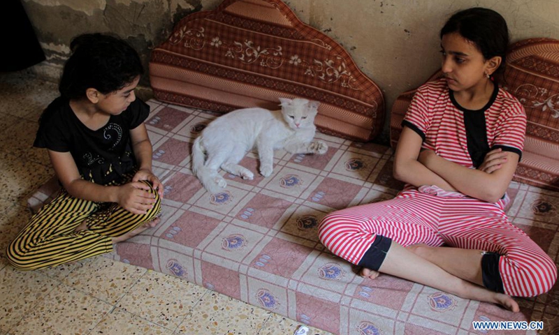 Members of Abu al-Khair family take care of a cat inside their house at Al-Shati refugee camp in Gaza City, on Aug. 8, 2021. Abu al-Khair family turned their home into a shelter to help stray cats in need, despite their difficult living conditions(Photo: Xinhua)