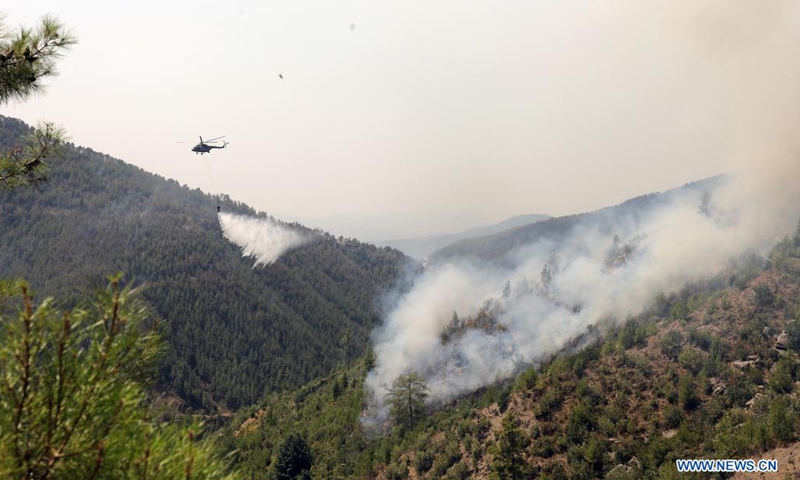 A helicopter douses wildfires in Koycegiz, Mugla province, southwestern Turkey, on Aug. 8, 2021. Turkey has been battling massive wildfires that erupted in southern and southwestern coastal resort towns 12 days ago. Most of them have been taken under control, according to municipal authorities.(Photo: Xinhua)